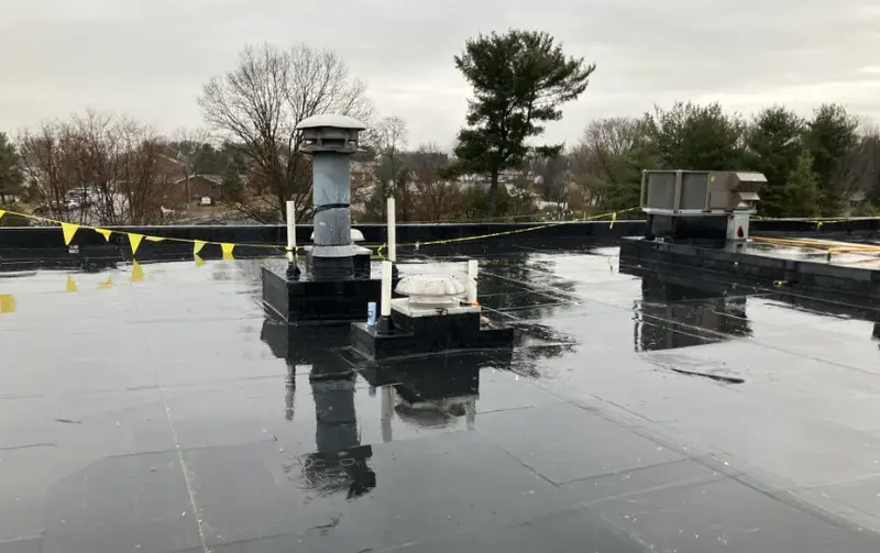 Black EPDM rubber roof with vent curbs and rooftop HVAC on a hotel
