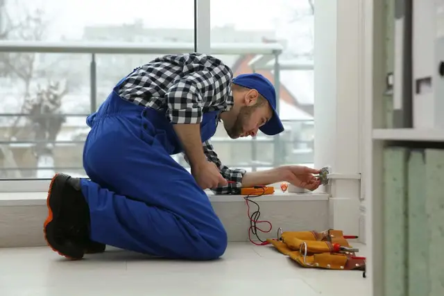 Technician repairing plumbing under a commercial sink