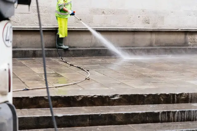 Contractor pressure washing a commercial building wall