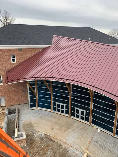 Aerial view of a commercial building with a new red standing seam metal roof
