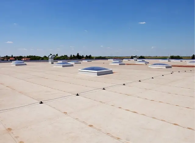 Aerial view of a flat commercial roof with rooftop units and colorful exterior panels