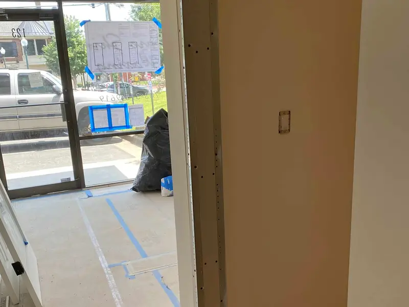 Retail suite under renovation with taped floors and partially painted walls