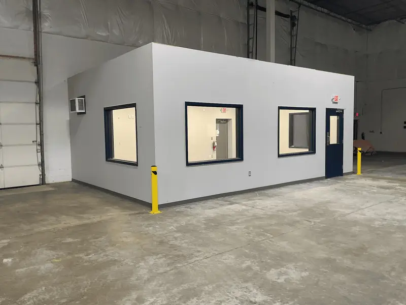 Prefabricated office with windows built inside a warehouse