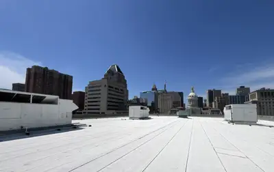 New white TPO roof with rooftop HVAC units overlooking the downtown Baltimore skyline