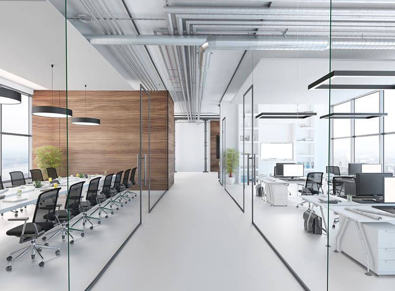 Modern office interior with glass partitions, precise commercial glass repair, wooden accents, ergonomic chairs and desks with computers; enhanced by bright lighting, exposed ceiling ducts, and potted plants for a natural touch.