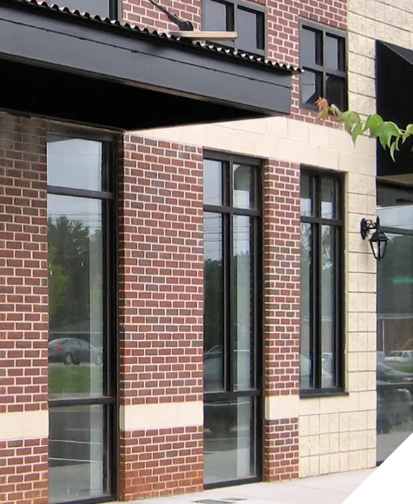 A storefront with expertly installed glass windows and classic red brick facade, showcasing quality exterior renovation work.