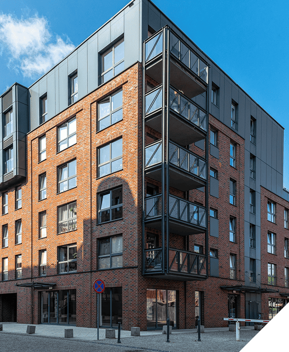 Modern apartment building with expert window installations and multiple balconies, set against a clear blue sky, showcasing premium exterior renovation services.