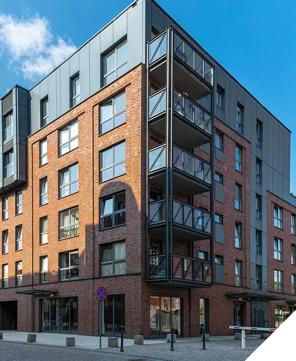 Modern apartment building with expert window installations and multiple balconies, set against a clear blue sky, showcasing premium exterior renovation services.