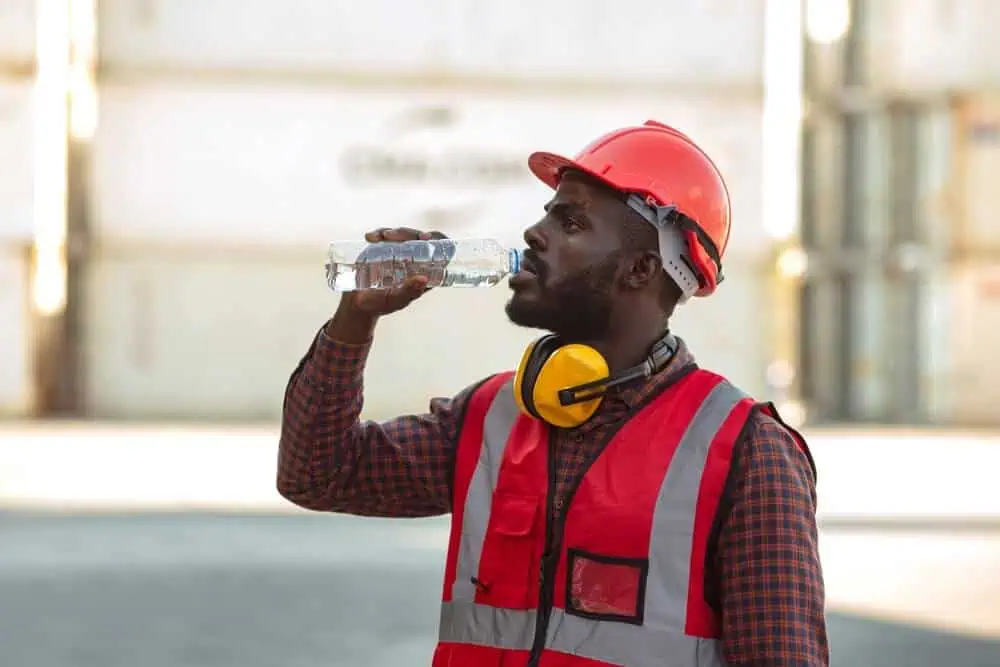 Construction worker staying hydrated working outside