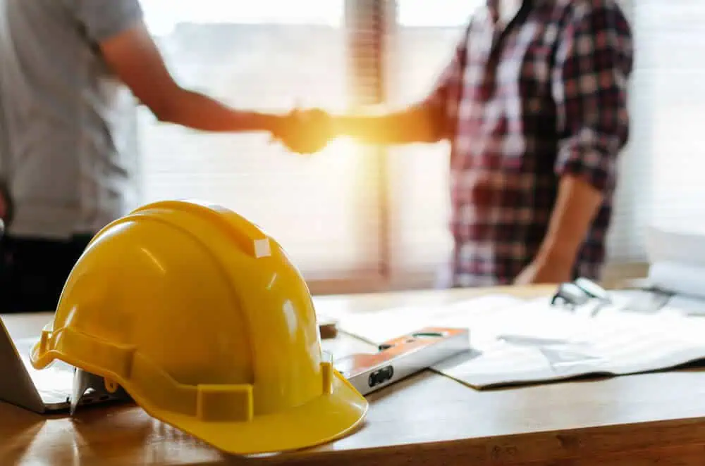 professional contractors shake hands on job site