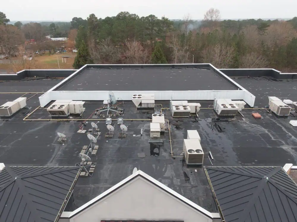 Black single-ply roofing on a commercial building with multiple levels and air handlers installed