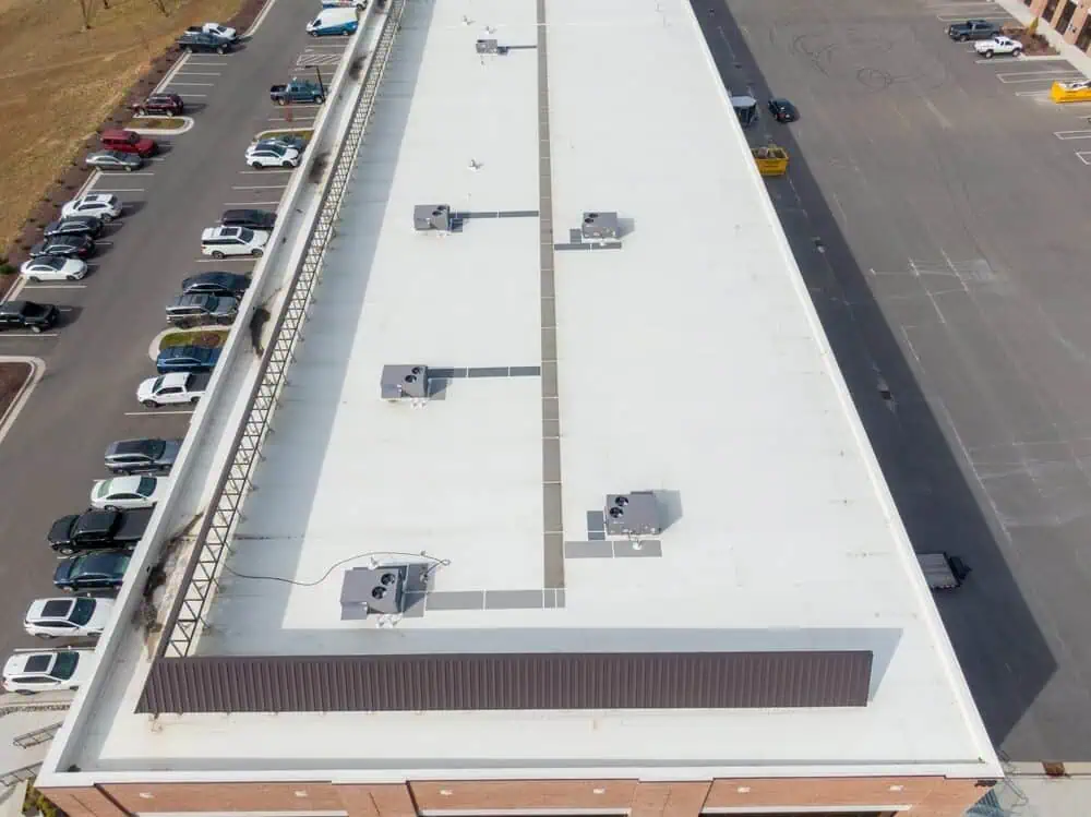 White TPO roofing ontop of a long commercial building with air handlers and walking paths