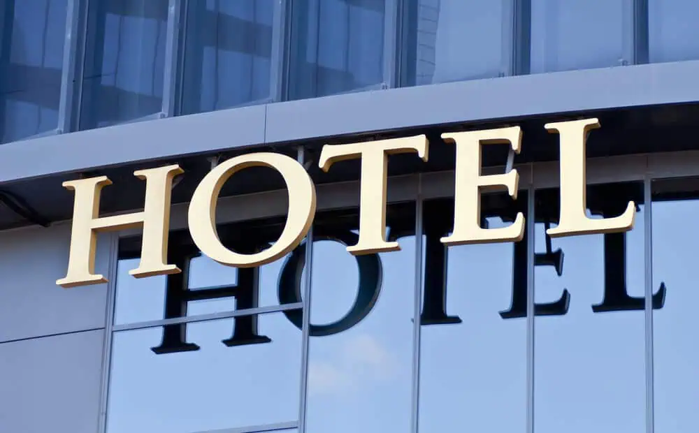 Exterior view of a building with reflective glass windows, featuring a large, gold "HOTEL" sign.