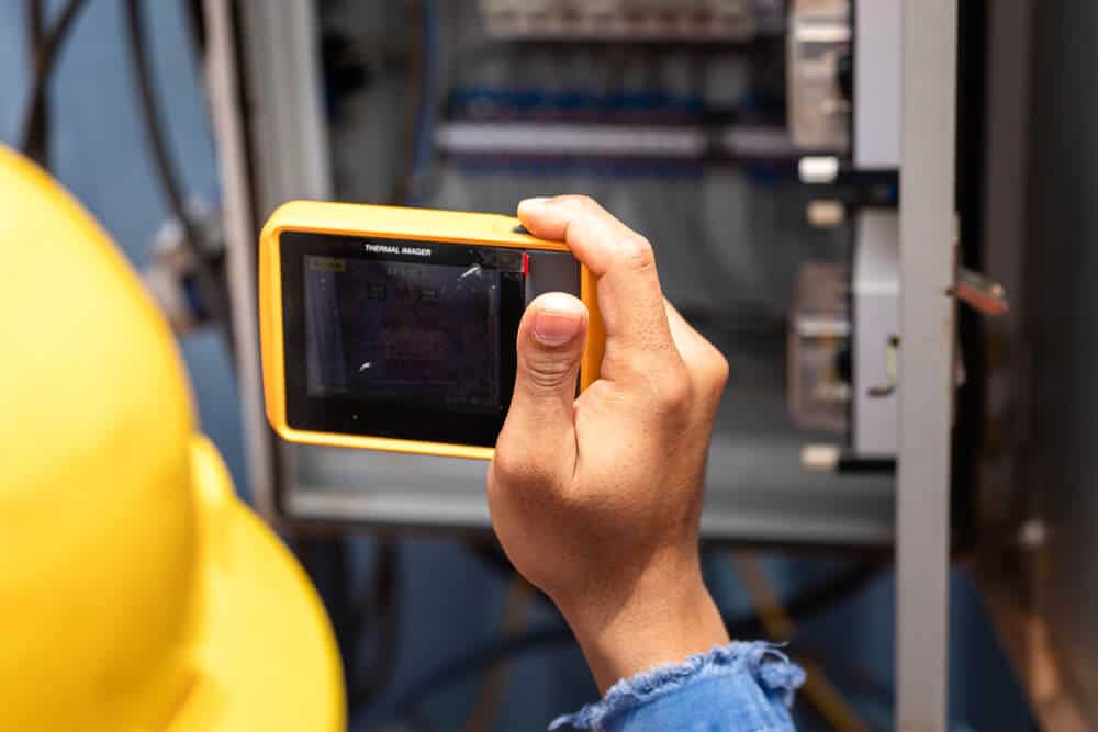 Thermal imaging camera inspecting electrical panel for safety and efficiency in renovation project.