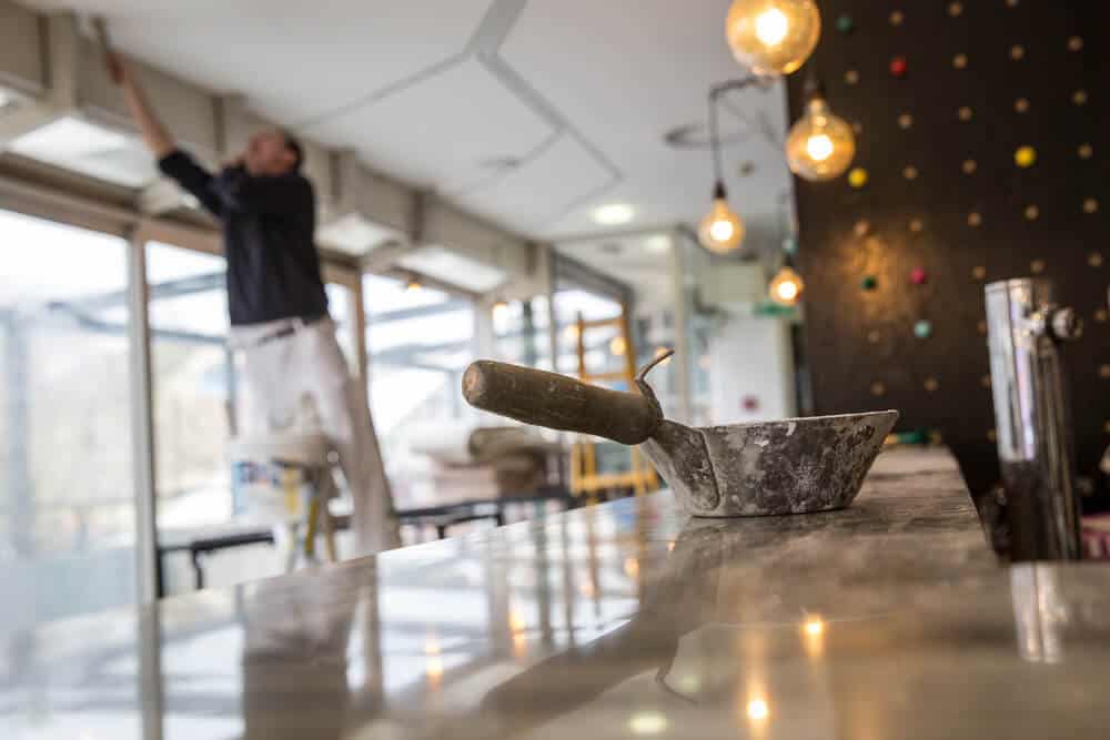Man paints ceiling during a restaurant renovation.