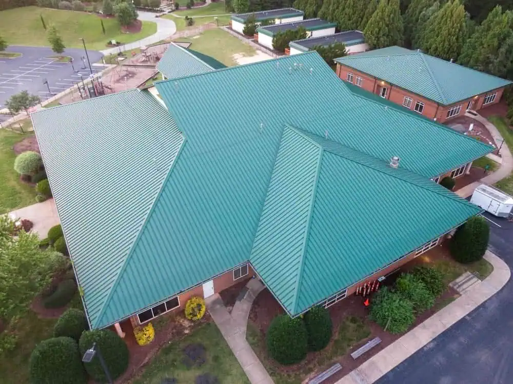 A brick school building with a standing seam metal roofing system