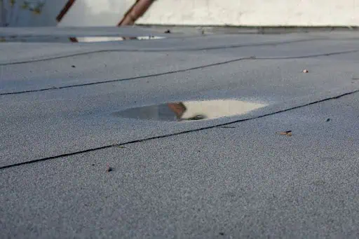 Ponding water on a commercial roof needing repair
